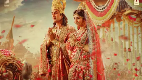 Ranbir Kapoor as Rama and Sai Pallavi as Sita, hands folded under falling rose petals, in the official Mangal Rang artwork from Ramayana