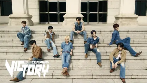 NTX, the eight-member K-pop group, sitting on wide stone steps in matching denim outfits and brown boots